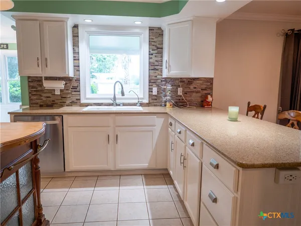 a sink with a large window and a rug