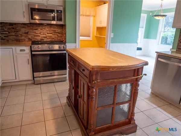 a kitchen with stainless steel appliances a refrigerator and a stove