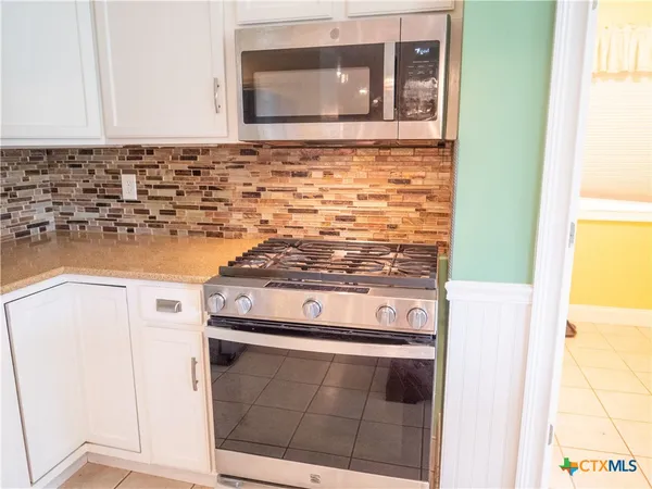 a kitchen with stainless steel appliances granite countertop a stove and a refrigerator