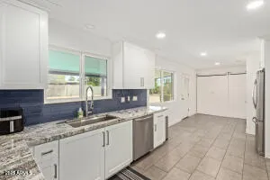 a kitchen with granite countertop a sink and a stove