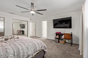 a bedroom with a bed and a flat screen tv