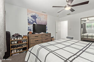 9001 North 13th Avenue Phoenix, AZ 85021 - Photo 17 of 25 a bedroom with a bed and a flat screen tv