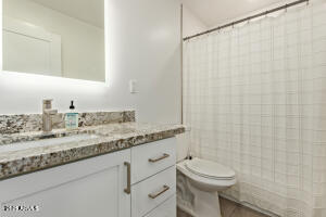 9001 North 13th Avenue Phoenix, AZ 85021 - Photo 20 of 25 a bathroom with a granite countertop sink a toilet and a mirror