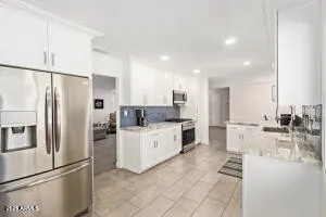 a kitchen with white cabinets and stainless steel appliances