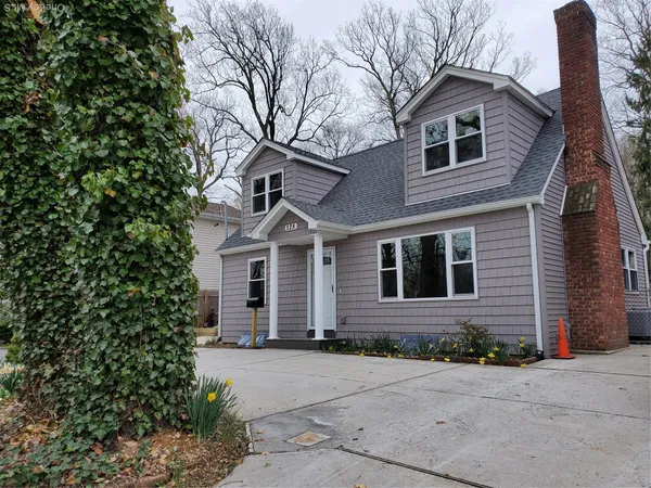 a front view of a house with yard and trees