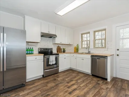 a kitchen with a white cabinets and wooden floor