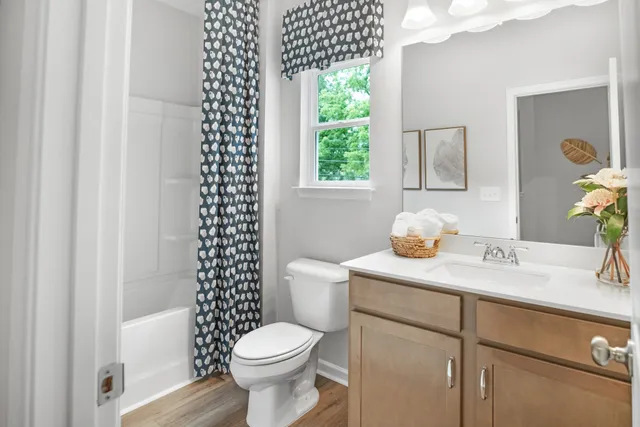 a bathroom with a sink a toilet and a window