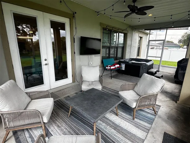 a living room with furniture a flat screen tv and a floor to ceiling window