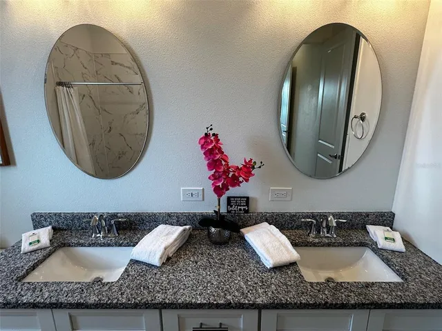 a bathroom with a granite countertop mirror and vanity