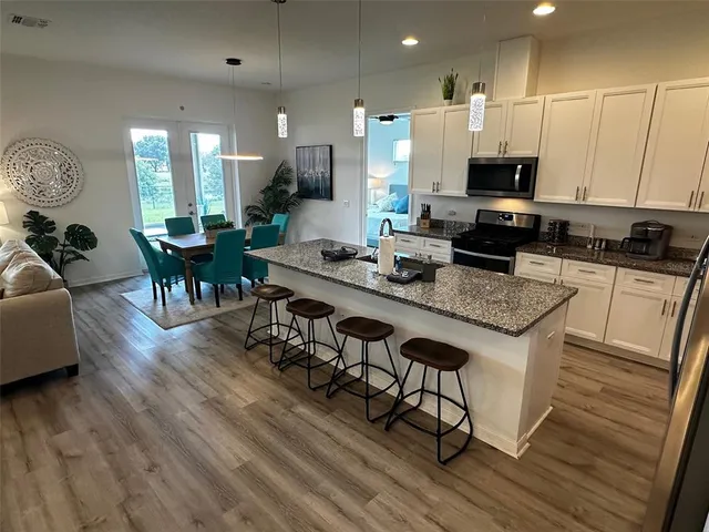 a large kitchen with kitchen island a sink table and chairs
