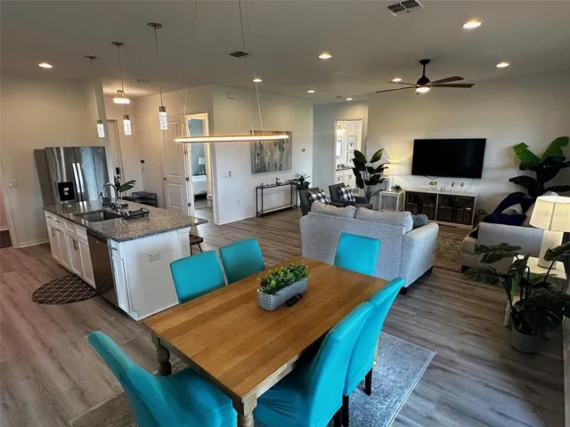 a living room with furniture a flat screen tv and kitchen view