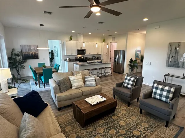 a living room with furniture and a view of kitchen
