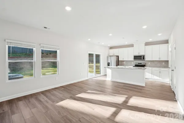 a open kitchen with granite countertop a stove top oven a sink and a granite counter top