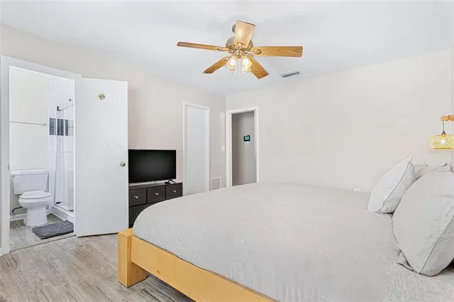 a bedroom with a bed and a ceiling fan