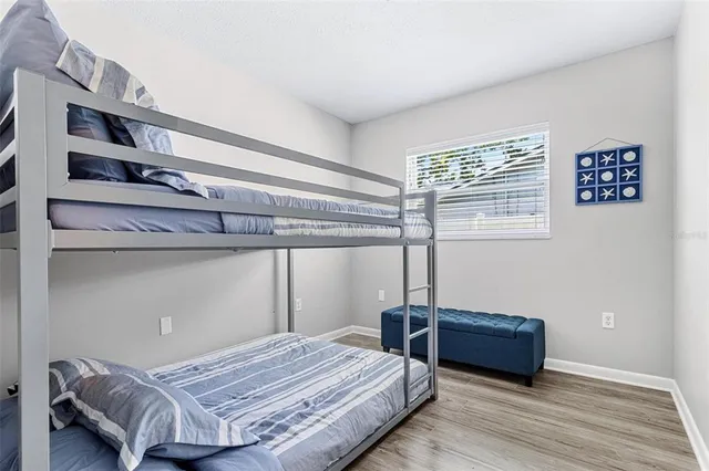 a bedroom with a bed and wooden floor