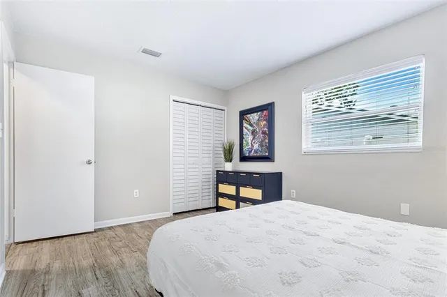 a bedroom with a bed and a painting on the wall