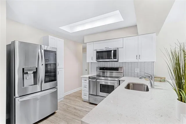 a kitchen with stainless steel appliances a refrigerator sink and microwave