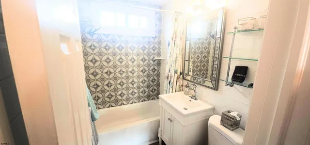 a bathroom with a sink a toilet and shower curtain