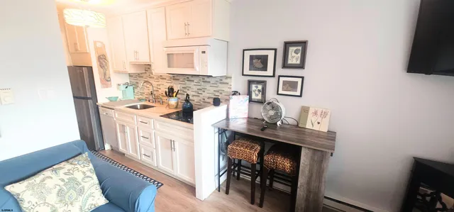 a living room with furniture a flat screen tv and a wall clock
