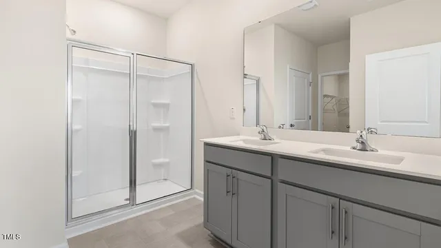 a bathroom with a double vanity sink mirror and shower