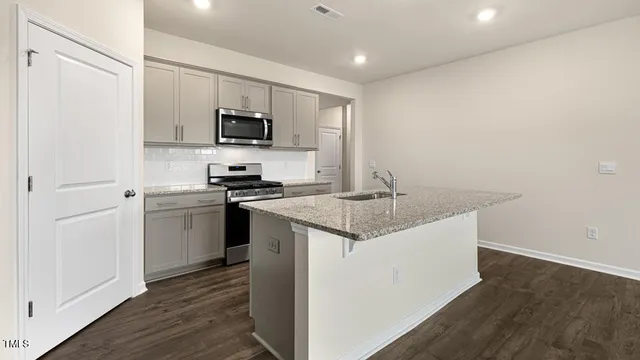 a kitchen with a sink stainless steel appliances and white cabinets