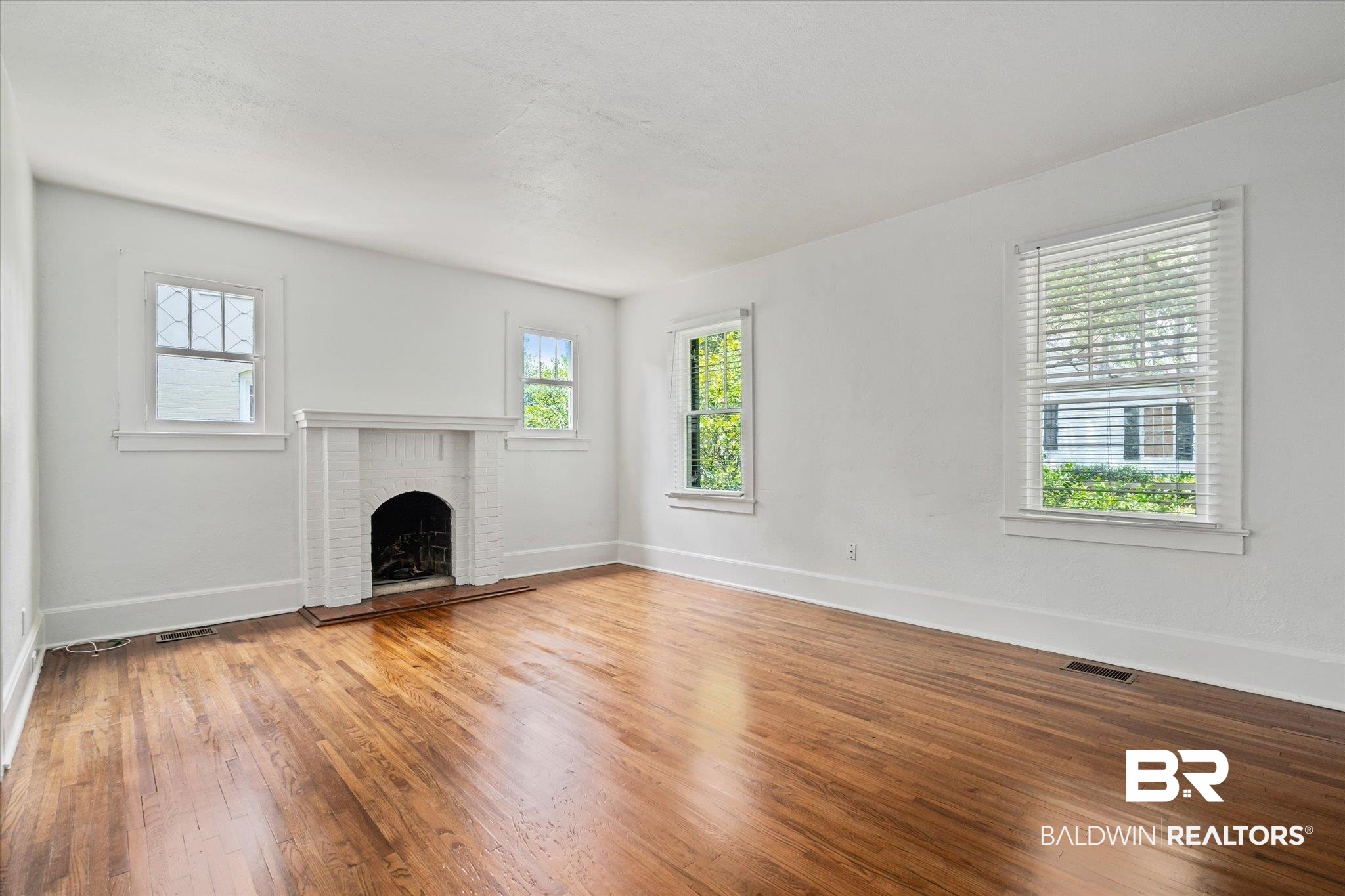 1159 Palmetto Street Mobile, AL 36604 - Photo 3 of 21 Unfurnished living room with a brick fireplace and wood-type flooring