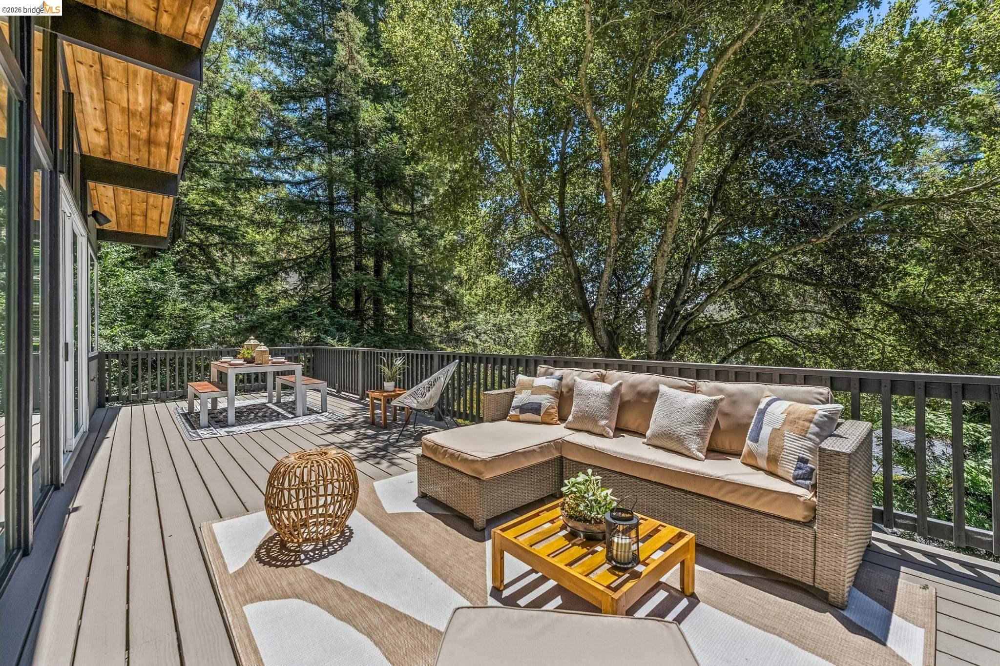 6645 Heather Ridge Way Oakland, CA 94611 - Photo 43 of 61 Expansive outdoor deck featuring composite decking, dark railings, and a wood-paneled overhang