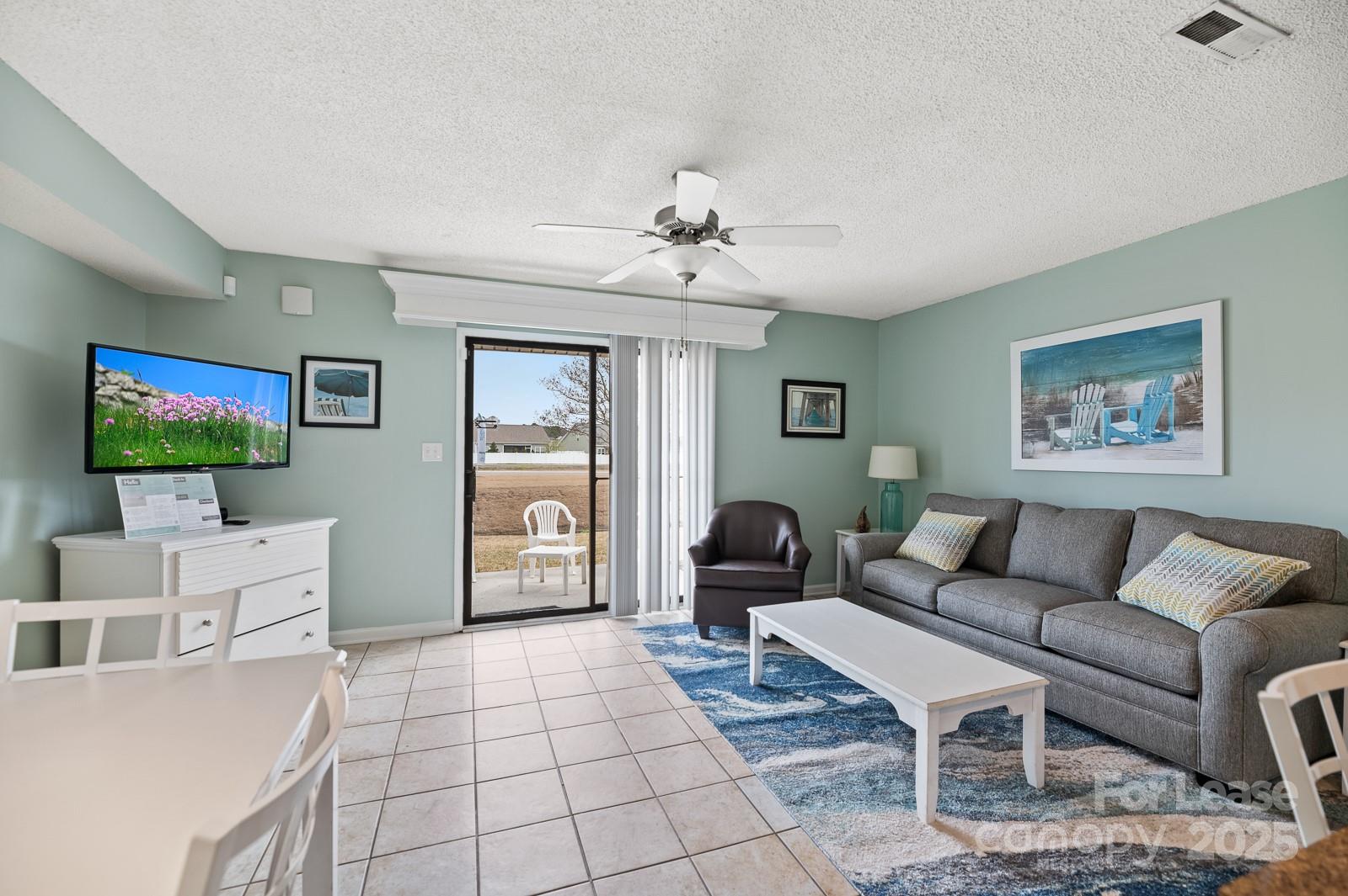 201 Double Eagle Drive, Unit E1 Surfside Beach, SC 29575 - Photo 11 of 19 a living room with furniture and a flat screen tv