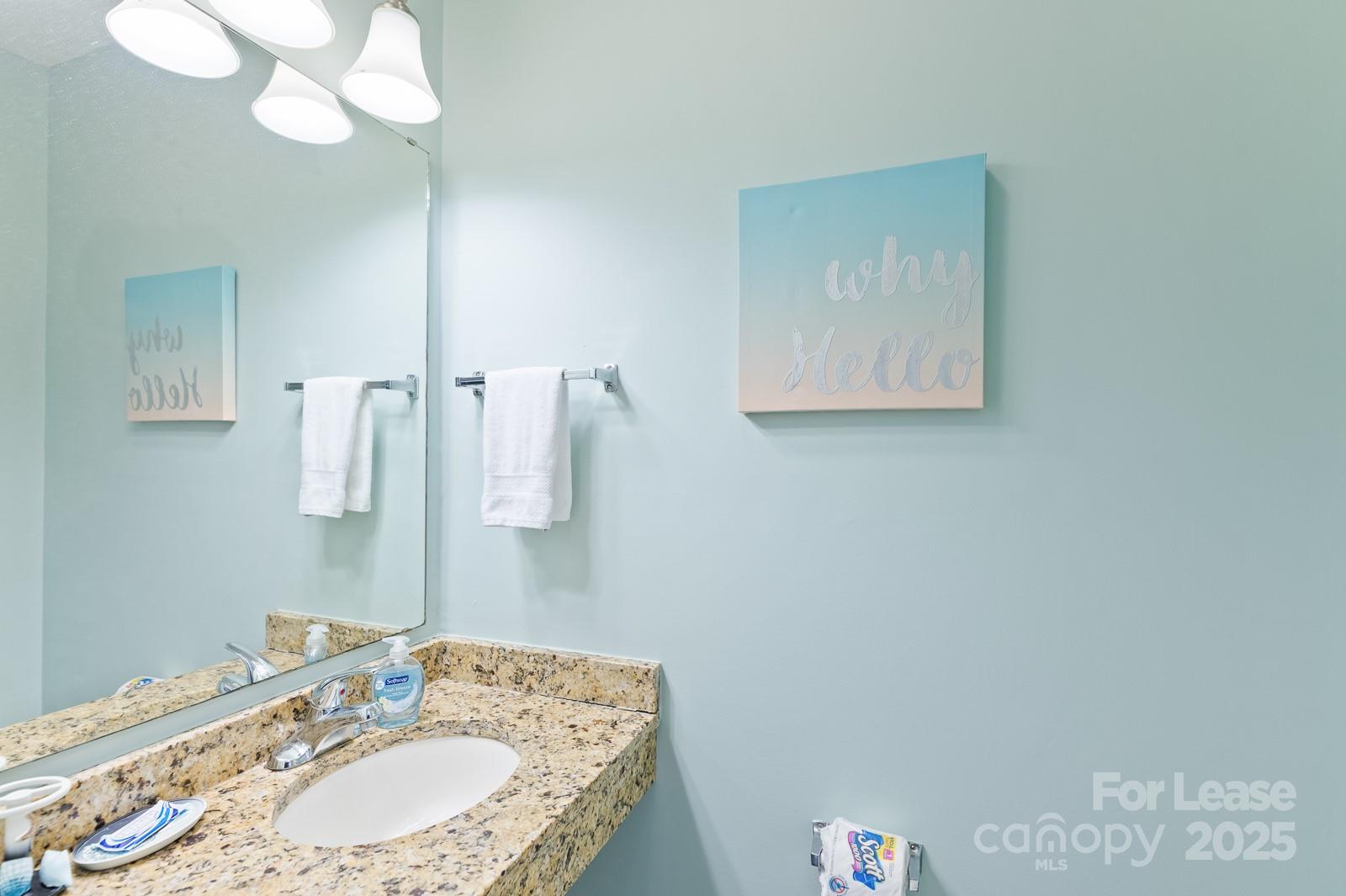 201 Double Eagle Drive, Unit E1 Surfside Beach, SC 29575 - Photo 12 of 19 a bathroom with a granite countertop sink a mirror and vanity