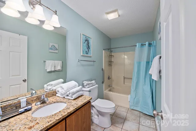 a bathroom with a granite countertop sink a toilet and shower