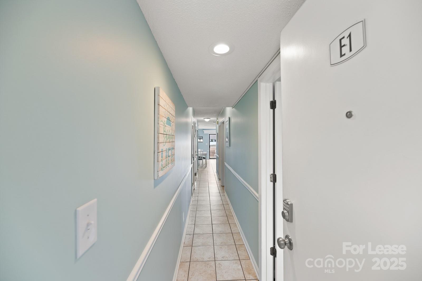 201 Double Eagle Drive, Unit E1 Surfside Beach, SC 29575 - Photo 2 of 19 a view of a hallway with wooden floor and staircase
