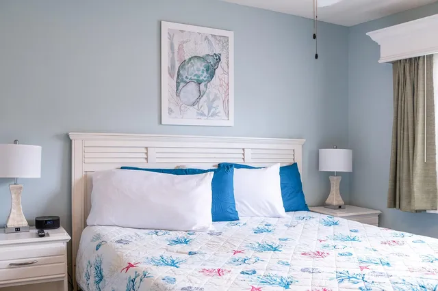 a bedroom with a bed and painting on the wall