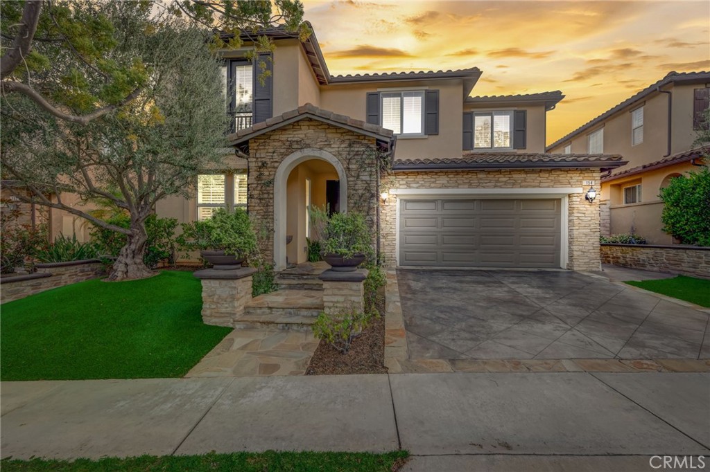 a front view of a house with a garden and plants