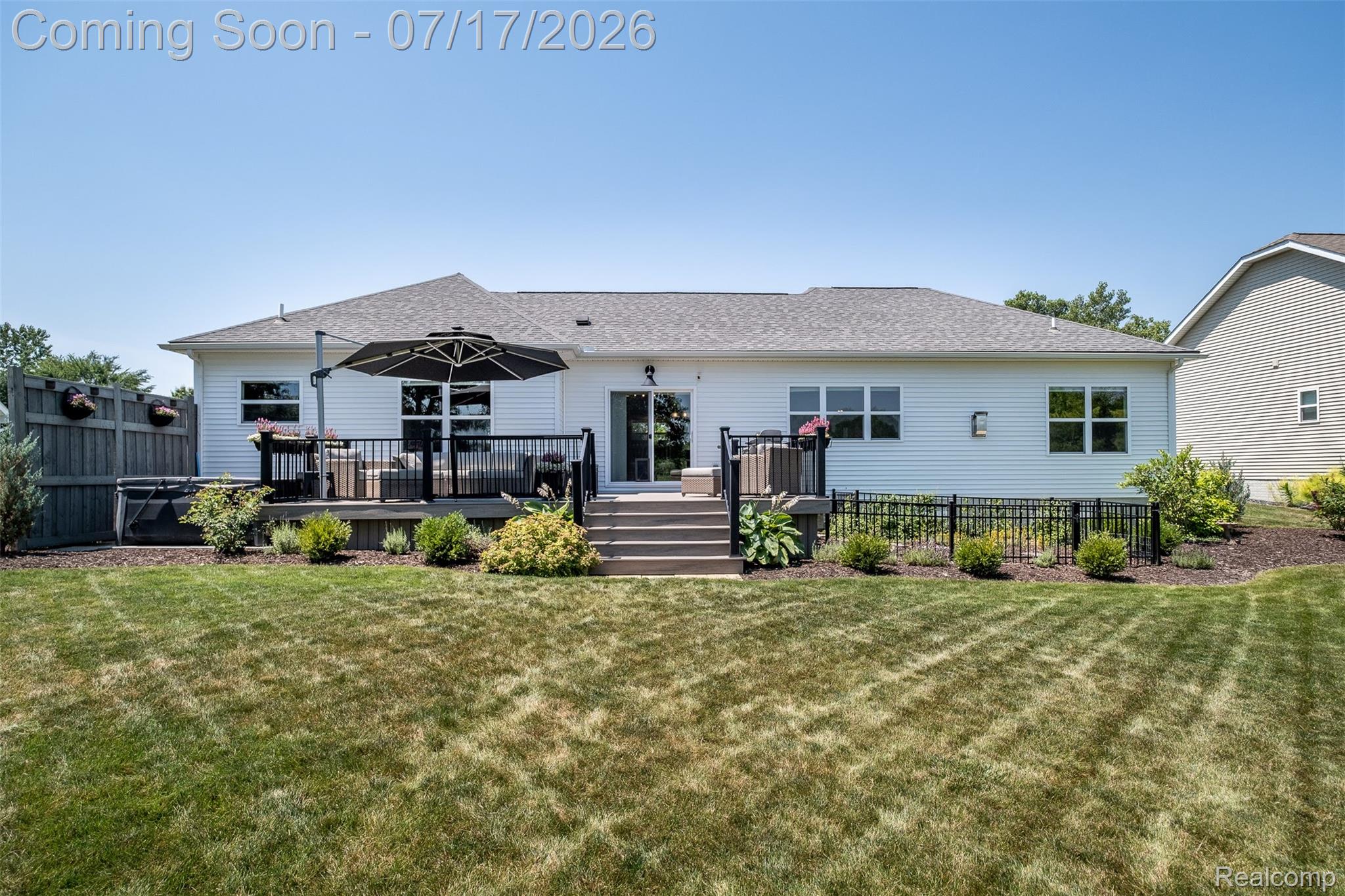 12349 Sugar Maple Drive Fenton, MI 48430 - Photo 55 of 67 Expansive backyard featuring a multi-level deck with black railings, a sliding glass door entry, multiple windows, and a privacy fence
