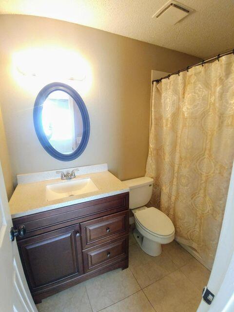 925 Southeast Albatross Avenue Port St. Lucie, FL 34983 - Photo 7 of 7 a bathroom with a toilet sink and mirror