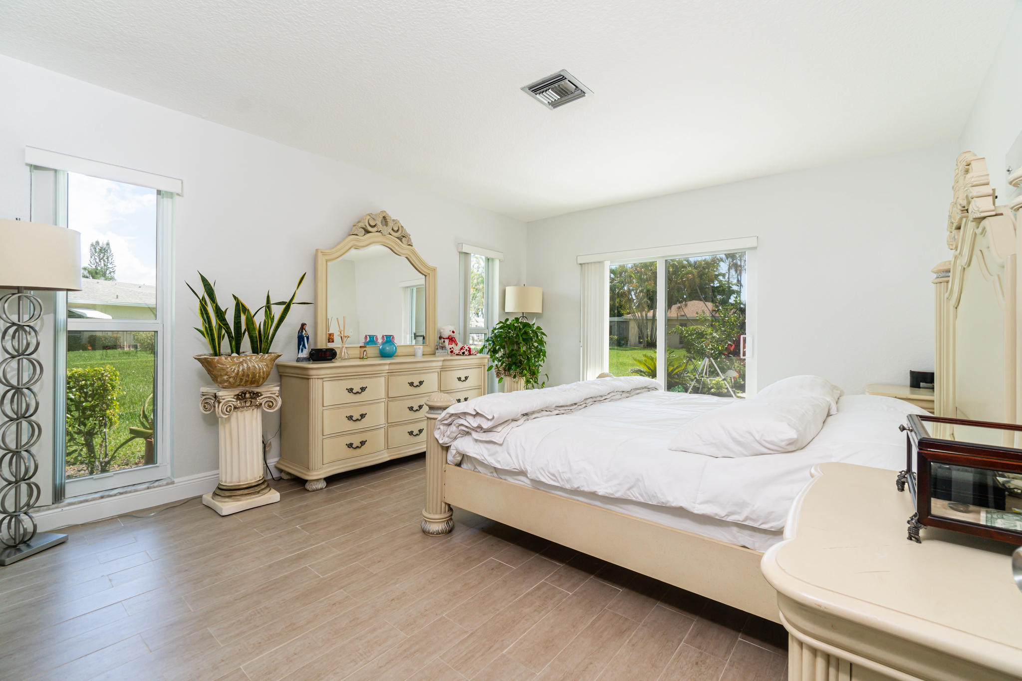 13831 Vía Flora, Unit A Delray Beach, FL 33484 - Photo 17 of 47 a bedroom with a bed and a large window