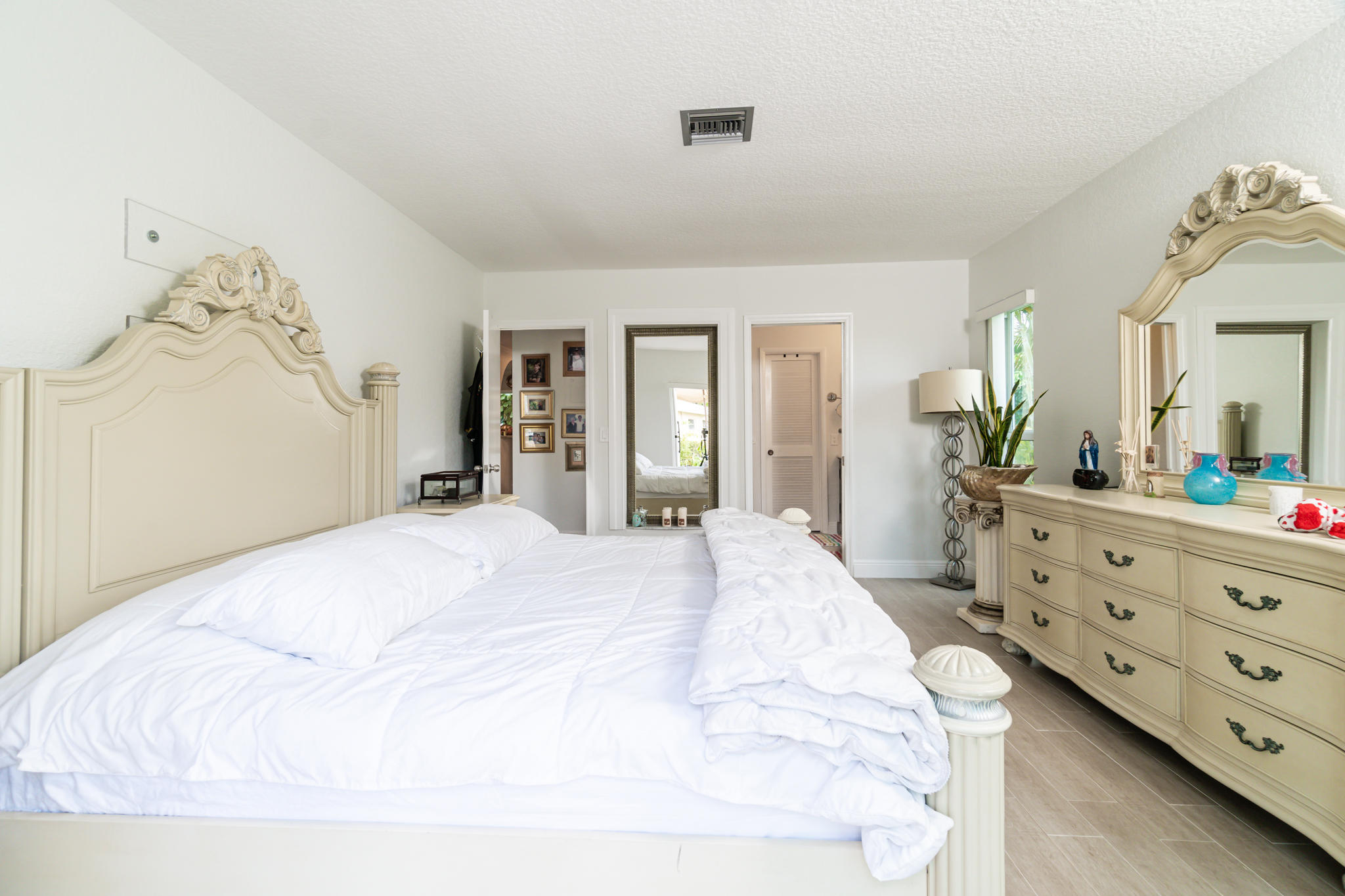 13831 Vía Flora, Unit A Delray Beach, FL 33484 - Photo 18 of 47 a bedroom with a bed and a dresser