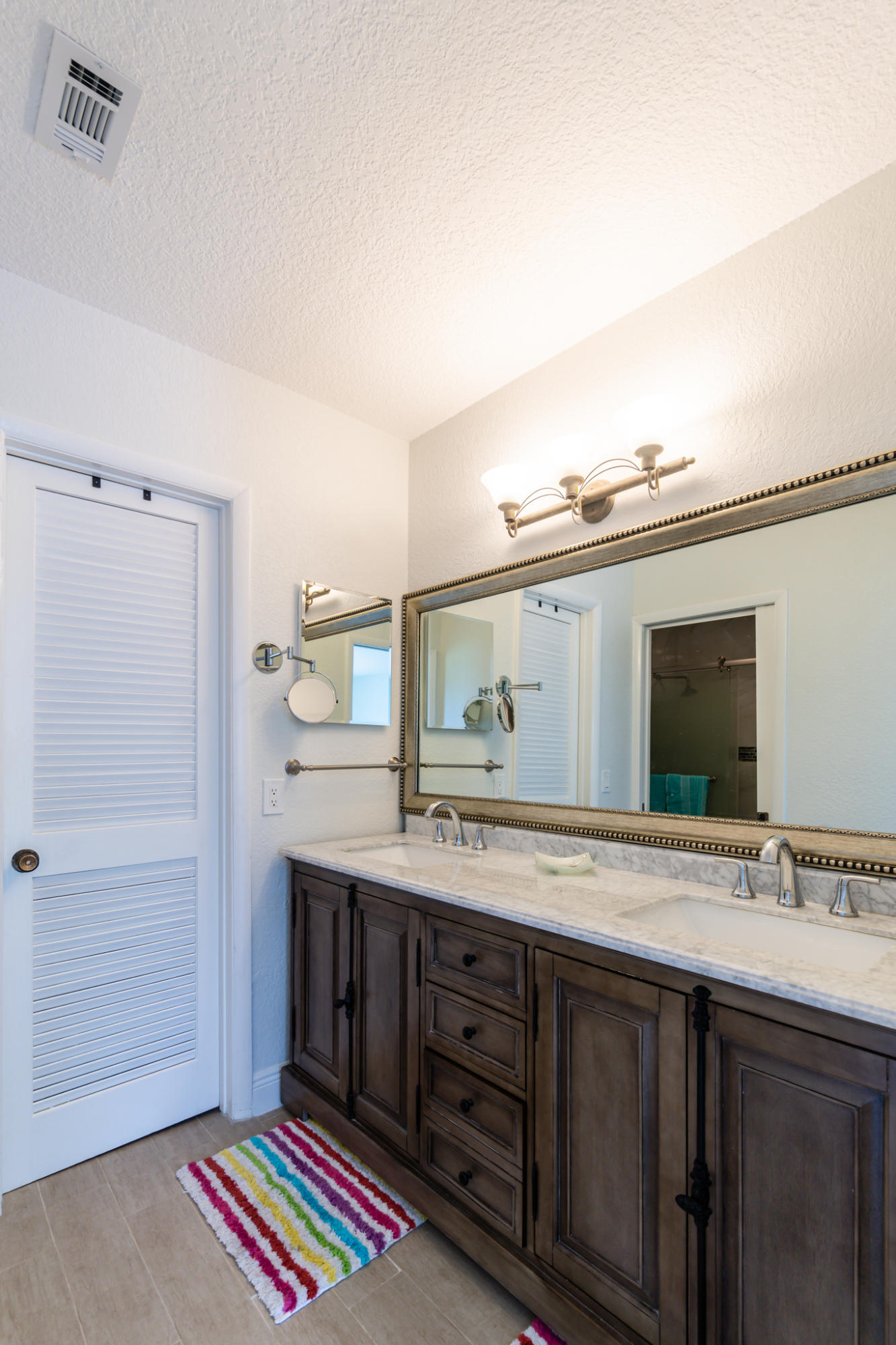13831 Vía Flora, Unit A Delray Beach, FL 33484 - Photo 19 of 47 a spacious bathroom with a sink a mirror and a shower