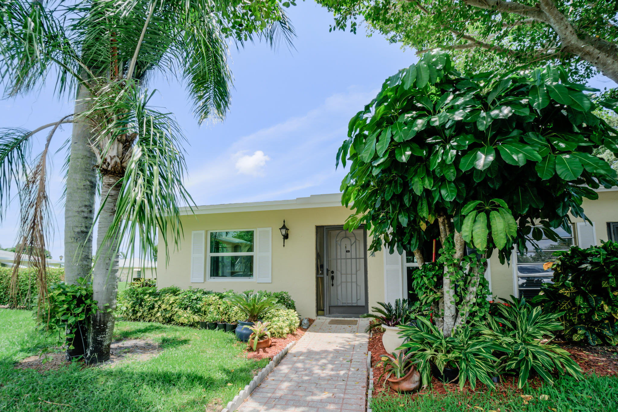 13831 Vía Flora, Unit A Delray Beach, FL 33484 - Photo 5 of 47 a front view of a house with a yard
