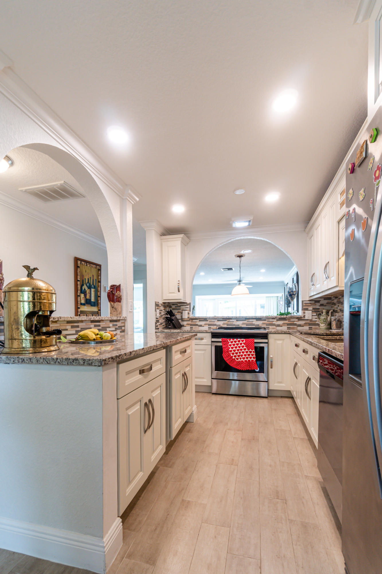 13831 Vía Flora, Unit A Delray Beach, FL 33484 - Photo 6 of 47 a kitchen with stainless steel appliances granite countertop a stove a sink and a refrigerator