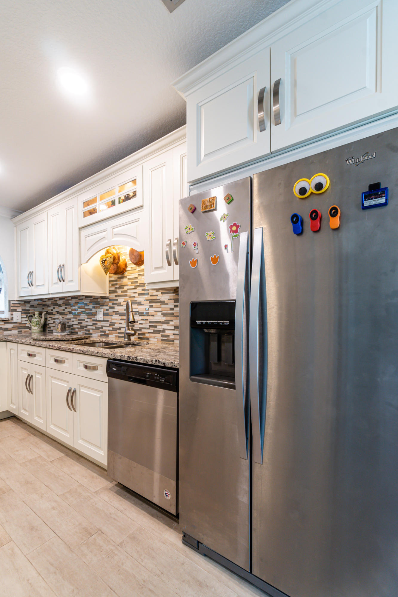 13831 Vía Flora, Unit A Delray Beach, FL 33484 - Photo 7 of 47 a kitchen with granite countertop stainless steel appliances and white cabinets