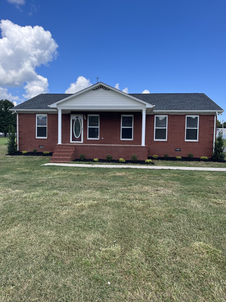 a front view of house with yard and trees all around