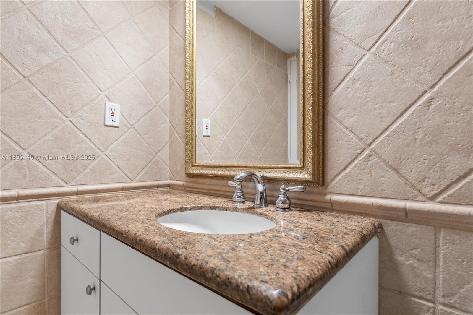 5700 Collins Avenue, Unit 10D Miami Beach, FL 33140 - Photo 25 of 47 a bathroom with a granite countertop sink and a mirror