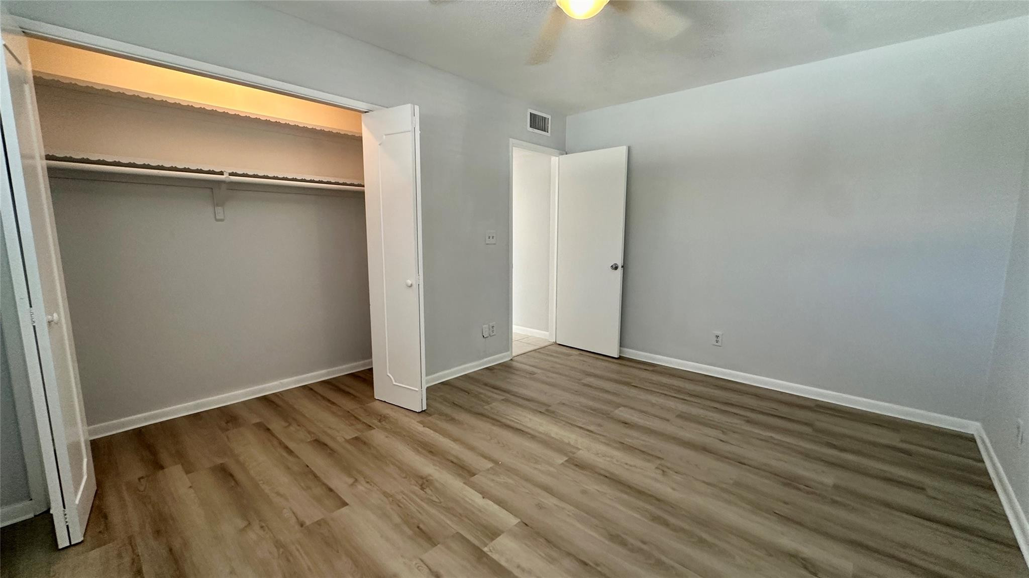 1900 Northeast 29th Street, Unit 2C Lighthouse Point, FL 33064 - Photo 12 of 21 a view of an empty room with wooden floor and a window