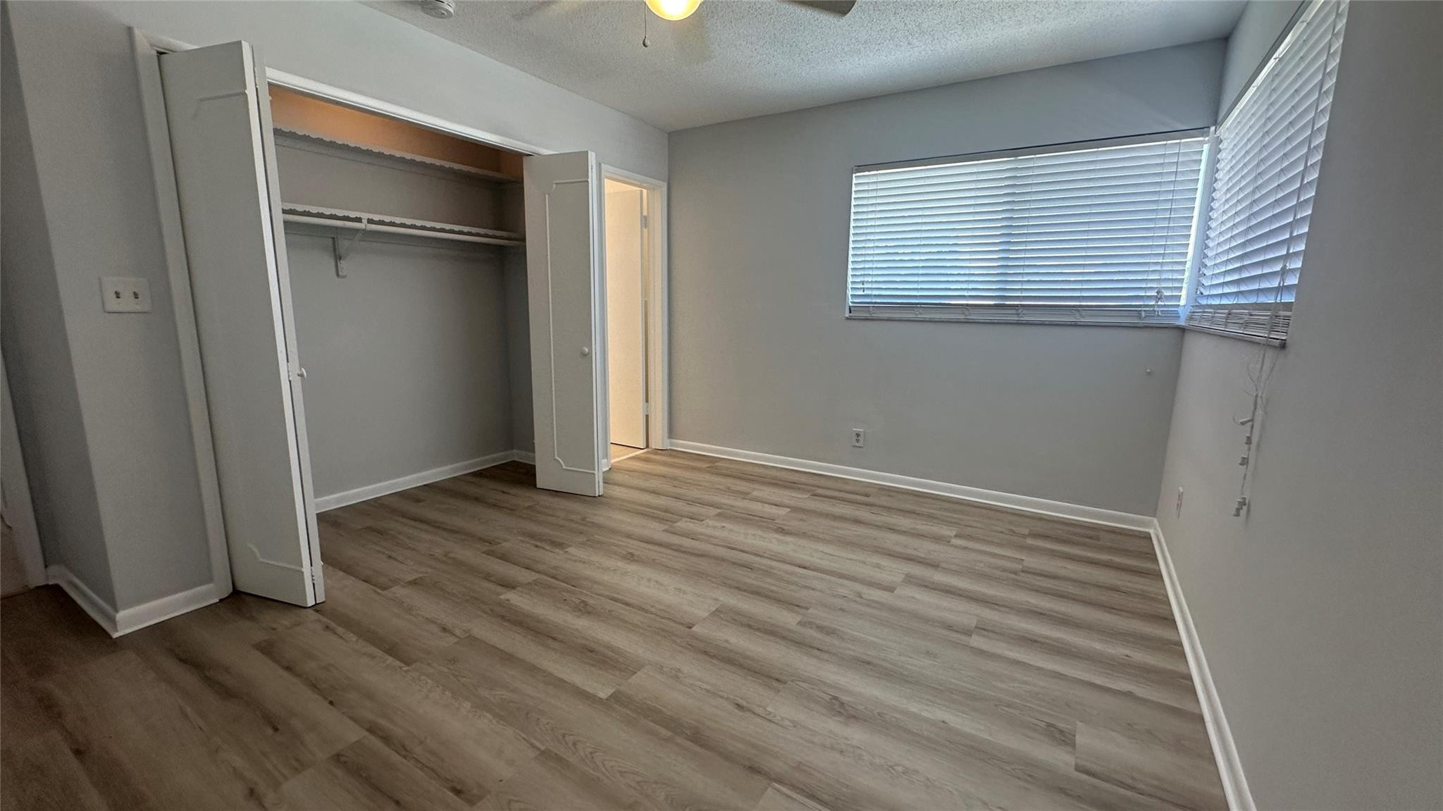 1900 Northeast 29th Street, Unit 2C Lighthouse Point, FL 33064 - Photo 7 of 21 an empty room with wooden floor closet and windows