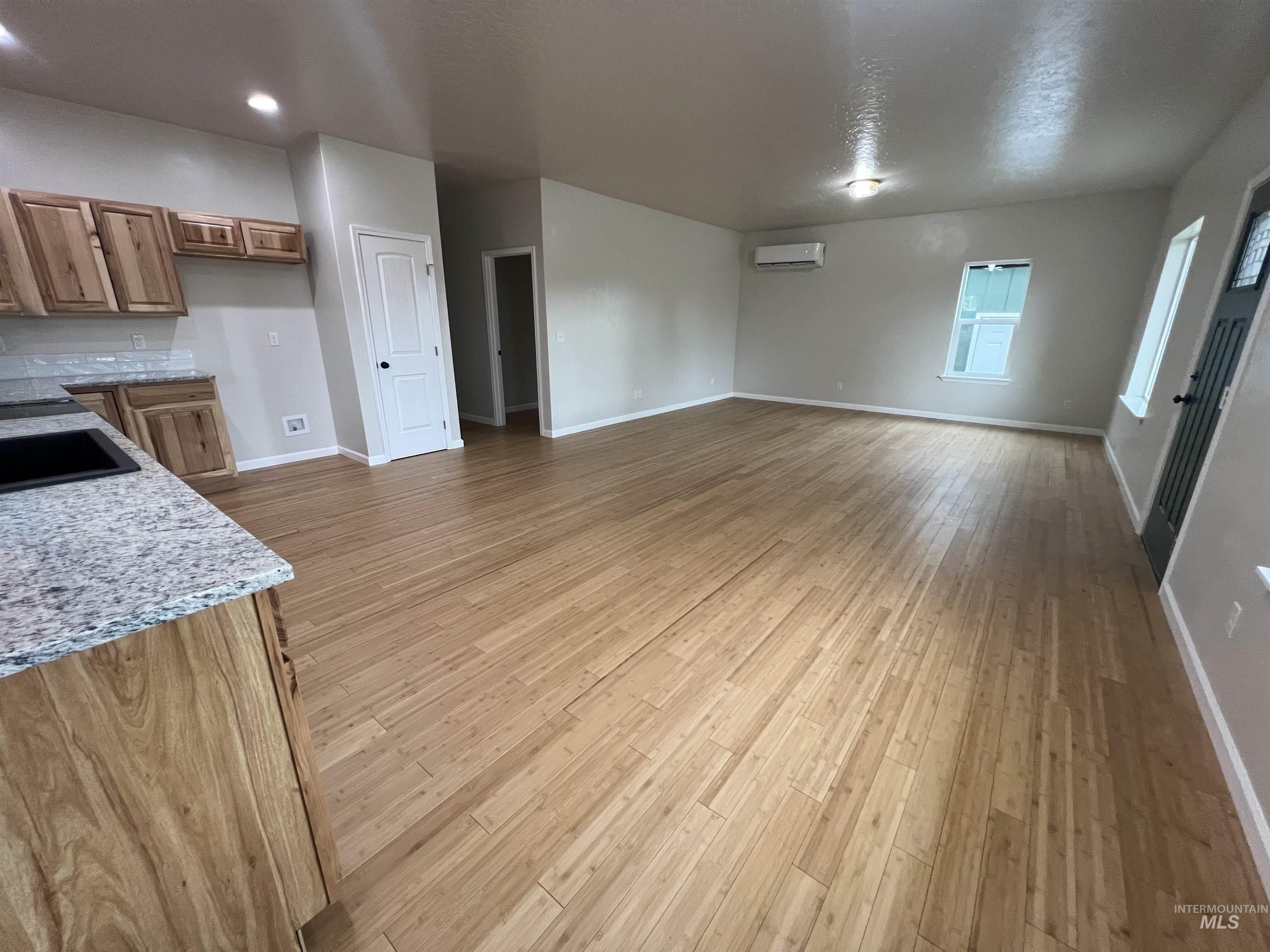 405 North Fairfield Street Council, ID 83612 - Photo 8 of 25 Unfurnished living room with light wood finished floors and a textured ceiling