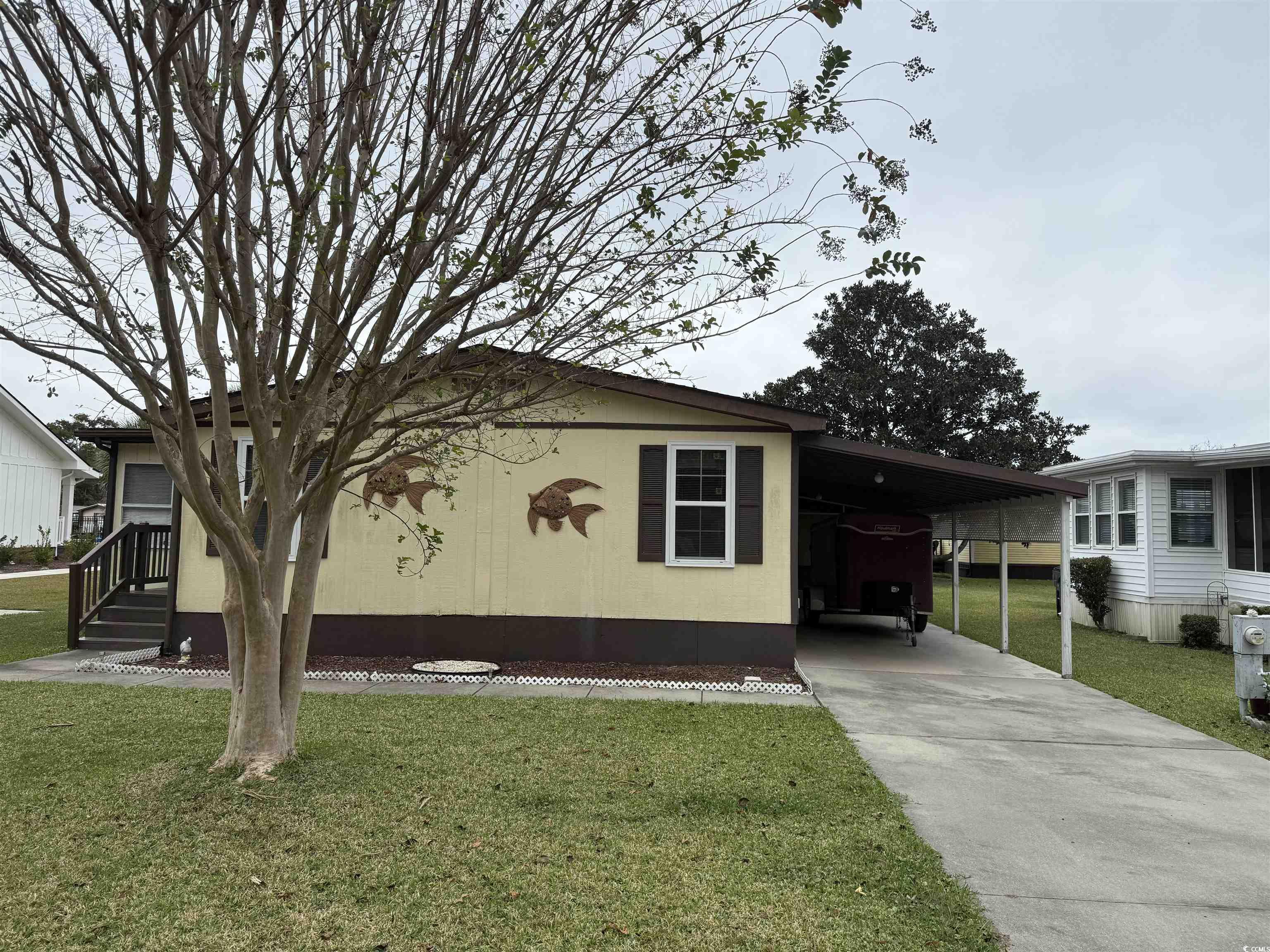 View of home's exterior with a yard, concrete driveway, and a carport