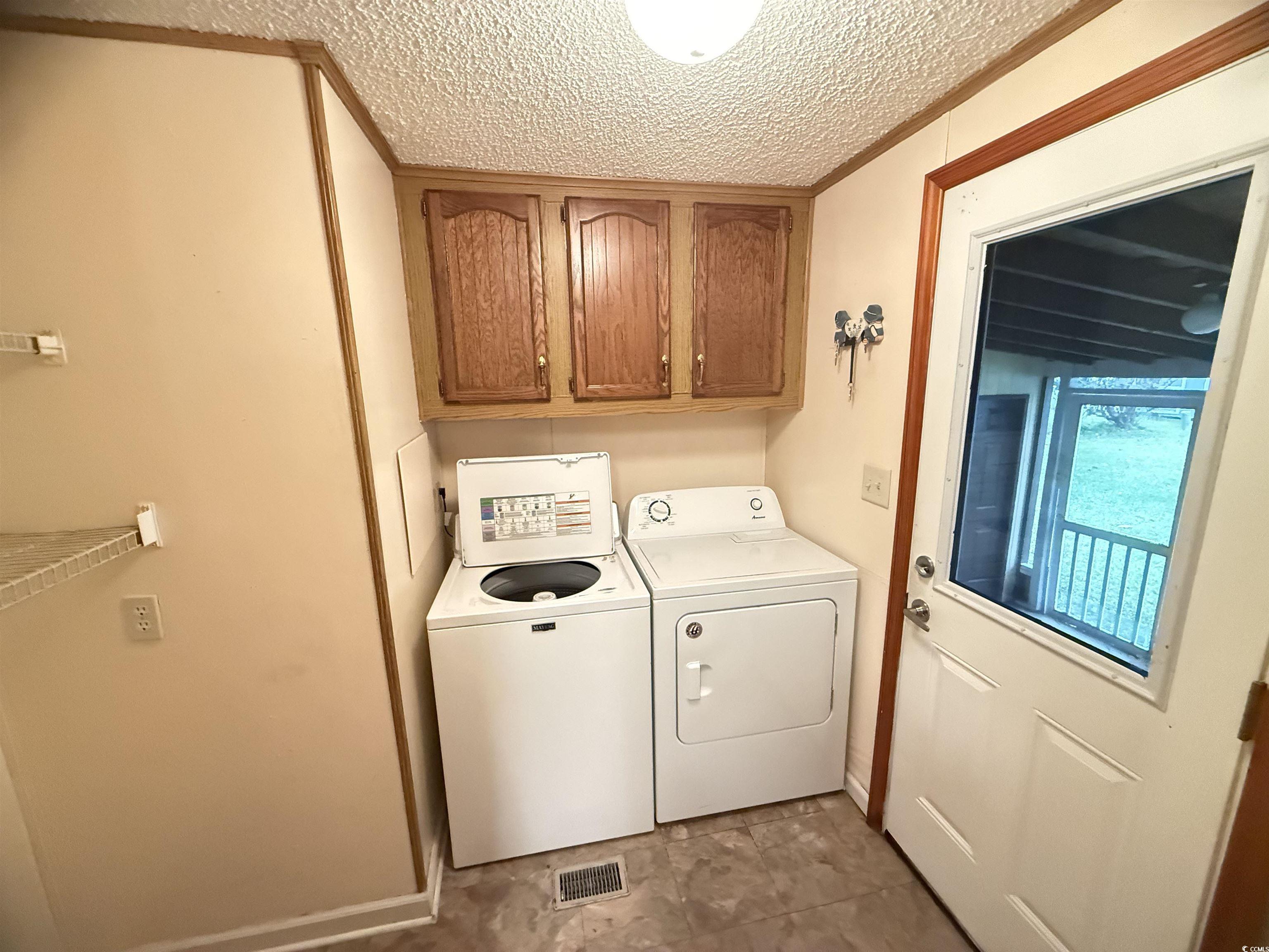 8 Buccaneer Street Murrells Inlet, SC 29576 - Photo 15 of 28 Laundry area featuring cabinet space, separate washer and dryer, and a textured ceiling