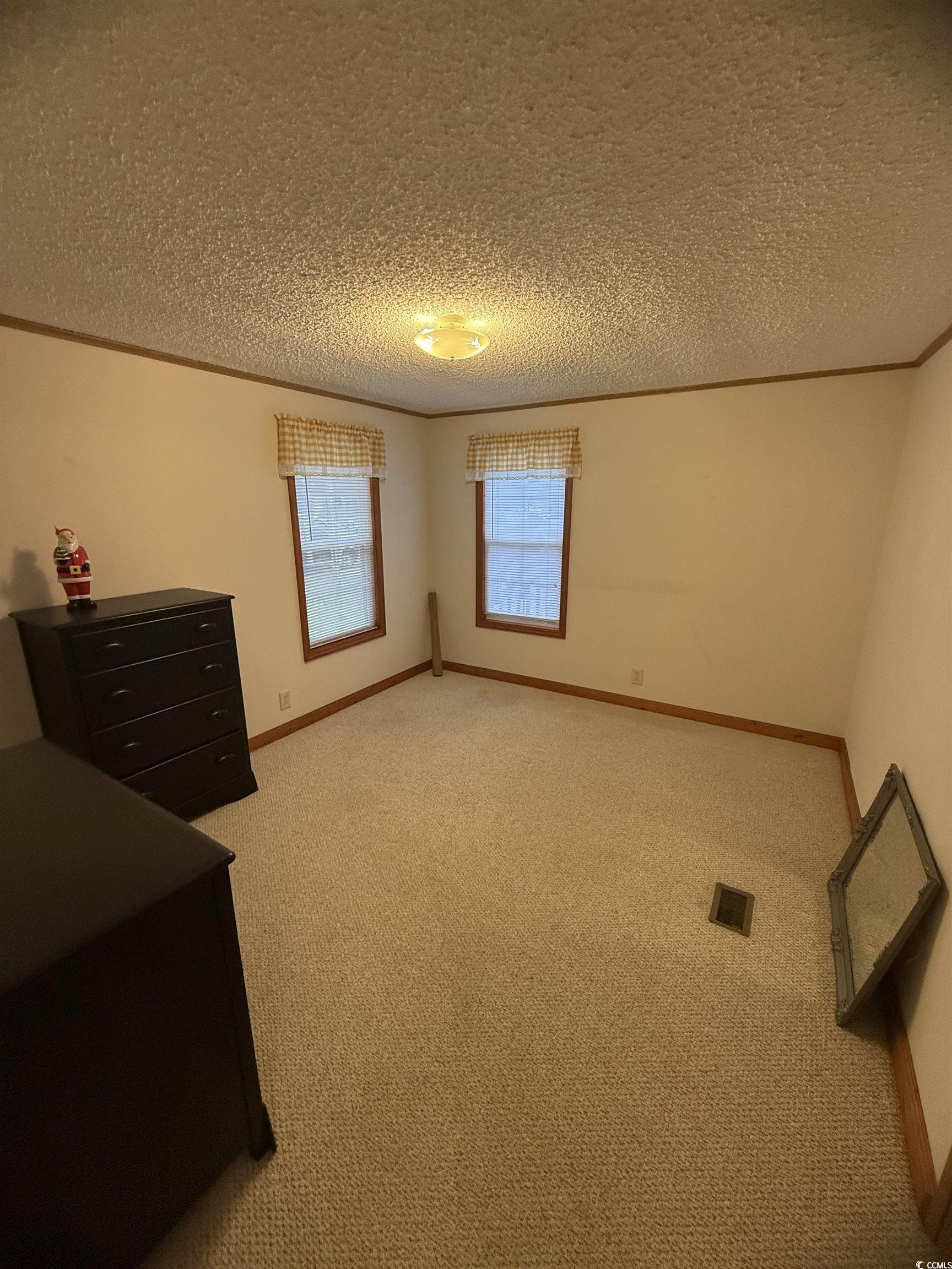 8 Buccaneer Street Murrells Inlet, SC 29576 - Photo 26 of 28 Unfurnished bedroom featuring light colored carpet, crown molding, and a textured ceiling