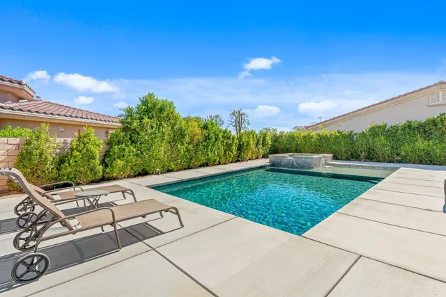a backyard of a house with table and chairs plants and large tree